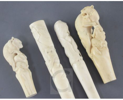 Four Japanese ivory walking stick or parasol handles, Meiji period, the first carved with a lioness attacking three monkeys, 