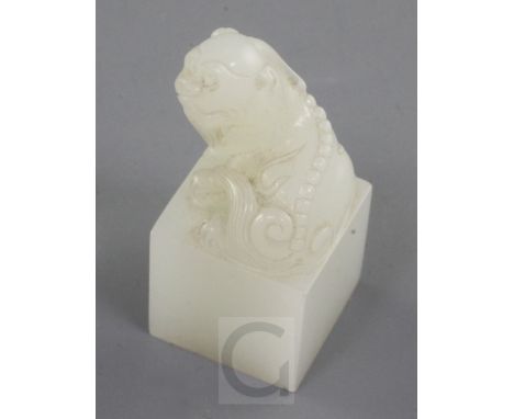 A Chinese white jade seal, early 20th century, carved with a lion-dog finial, the matrix with a four character inscription, t