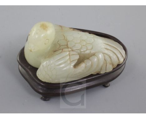 A Chinese celadon and russet jade figure of a recumbent bird, Ming dynasty, with detail to the feathers on its wings and tail