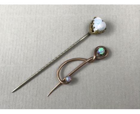 An early 20th Century yellow-metal and opal patented stick pin, bearing design registration mark, tests as gold, together wit