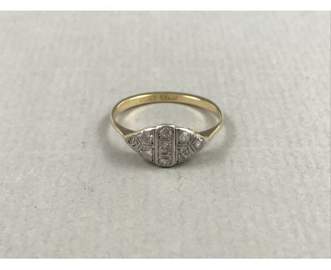 A 1930s diamond ring, the lenticular white-metal face being divided into geometric cells and illusion-set with brilliant-cut 