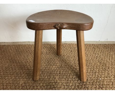 A Robert "Mouseman" Thompson (1876-1955) carved oak cow stool, having kidney shaped adzed top and three tapered octagonal leg