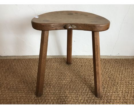 A Robert "Mouseman" Thompson (1876-1955) carved oak cow stool, having kidney shaped adzed top and three tapered octagonal leg