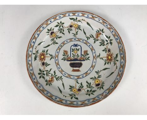 An 18th Century Delftware tin-glazed plate, polychrome-decorated in depiction of a stylised basket of flowers within a runnin