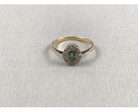 An early 20th Century emerald and diamond ring, having a square cut emerald of approximately .18ct, surrounded by a faceted w