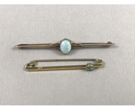 An early 20th Century opal and yellow-metal bar brooch, the cabochon being millegrain set and centrally held within trifurcat