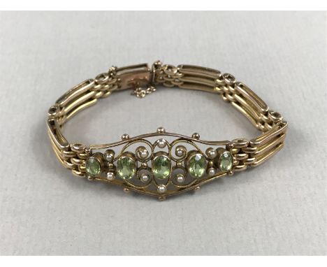A Belle Epoch peridot, pearl and precious yellow-metal bracelet, having an openwork face centrally millegrain set with five o