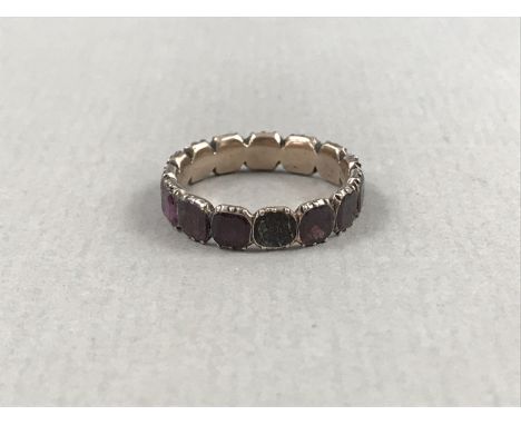 A Georgian almandine garnet and yellow metal eternity ring, the single cut stones being held in a pinched collet setting with