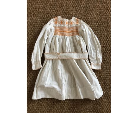 An early 20th Century child's Bohemian influenced cotton dress, having a squared yoke with hand-embroidered feather stitching