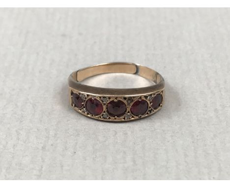 An early 20th Century garnet and diamond dress ring, the subtly bulbous face pellet-set with five graded round-cut garnets, t