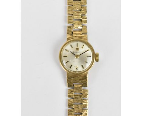 A Tissot manual wind, ladies 9ct gold wristwatch having a silvered dial with baton markers, 9ct gold bracelet and clasp, the 