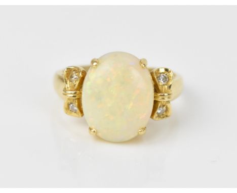 An 18ct yellow gold, opal and diamond dress ring, with central oval cabochon white opal flanked with two diamond accents in a