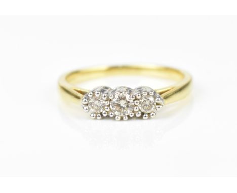 An 18ct yellow gold and three stone diamond ring, the three central stones with double prong white metal setting, size O, wei