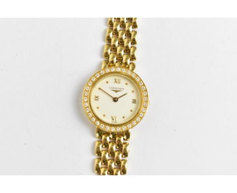 A Longines, quartz, ladies 18ct gold wristwatch having a diamond set bezel, white enamel dial with Roman numerals and pellets