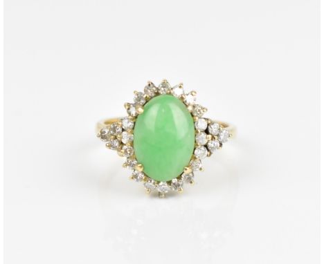 A 14ct yellow gold, diamond and green jade dress ring, with central oval cabochon jade in a halo of diamonds flanked by three