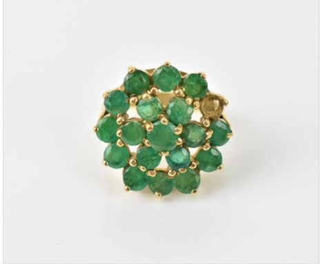 A 9ct yellow gold and emerald cluster dress ring, mounted with eighteen round cut emeralds, one missing, the shank hallmarked