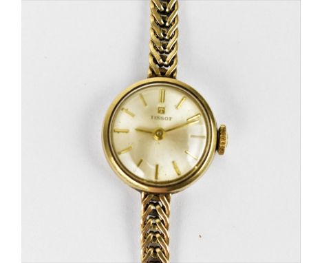 A Tissot manual wind, ladies 9ct gold wristwatch having a silvered dial with baton markers, 9ct gold bracelet and clasp, the 