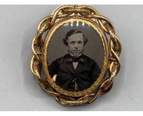 A Victorian yellow metal brooch with a photographic portrait of a man 37.1g gross