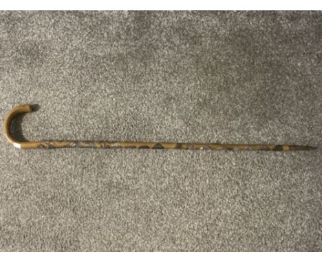 A walking stick with applied souvenir badges