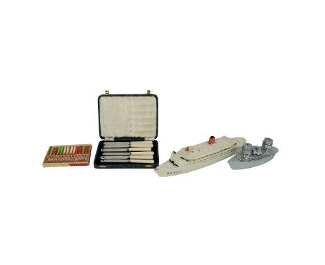 A cased set of 6 Art Deco butter knives by Unity, an Art Deco white metal cruet set in the form of a ship, a porcelain model 