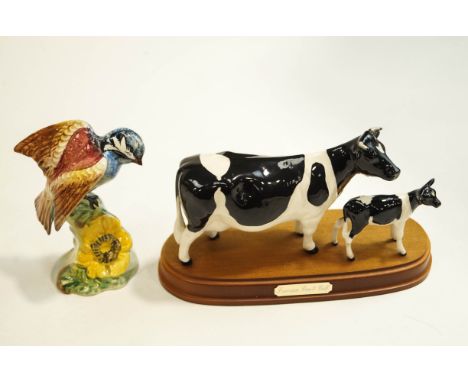 A Beswick Friesian cow and calf, upon a wooden base, and a Beswick model of a bird