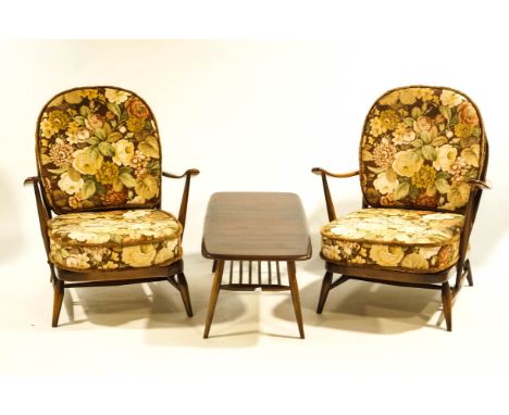 A pair of Ercol Windsor stick back armchairs, with floral patterned cushions, together with an Ercol coffee table, 105cm long