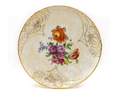 A large Continental porcelain plate,early 20th century, with moulded and gilt highlighted rim, the central field painted with