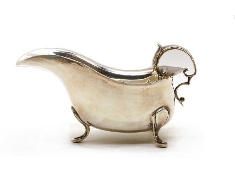 A George III style silver sauce boat, JPH, Birmingham 1934, of conventional form with a scalloped rim, a stylised foliate thu