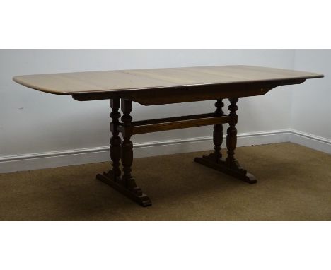 Ercol medium elm extending dining table, four baluster supports joined by stretchers on sledge feet, W92cm, H74cm, D203cm Con