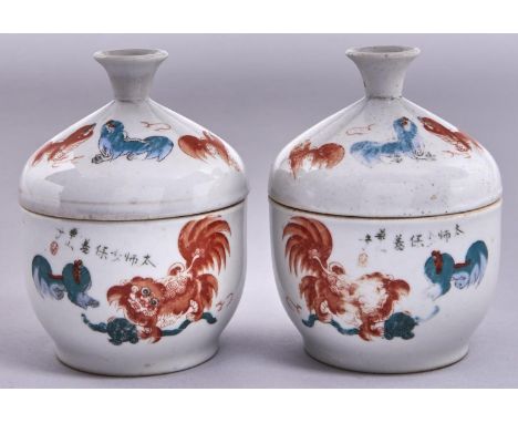 A pair of Chinese porcelain jars and covers, early 20th c, painted in iron red and green enamel with Shishi and inscribed, 13