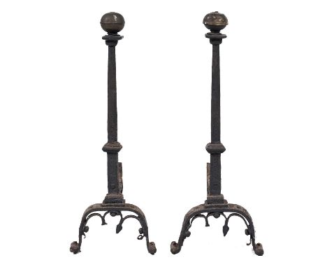 A pair of French iron firedogs, early 17th c, the slightly tapered chamfered pillar with square capital and globular brass fi