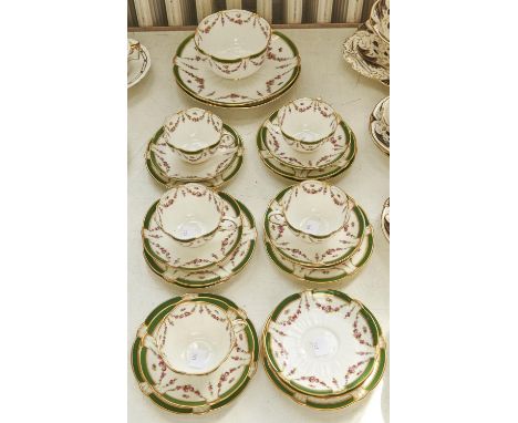 A George Jones bone china tea service, c1910, printed and painted to both interior and exterior with swags of roses below gre