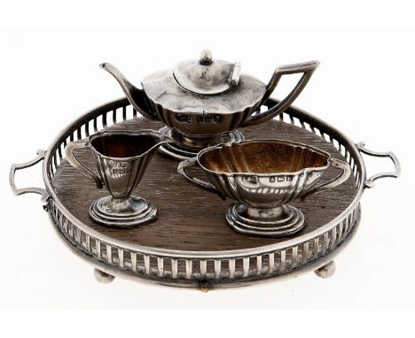 An Edwardian silver toy tea service, including circular tray with oak base, 90mm over handles, by Levi &amp; Salaman, Birming