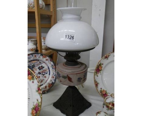 A late Victorian oil lamp on cast iron base with glass font and shade, no damage to glass, COLLECT ONLY.