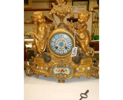 A French mantel clock with Sevres hand painted panels featuring cherubs. In working order, COLLECT ONLY.Has pendulum and Bell