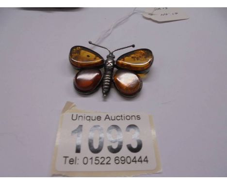 A vintage butterfly brooch in amber and silver.