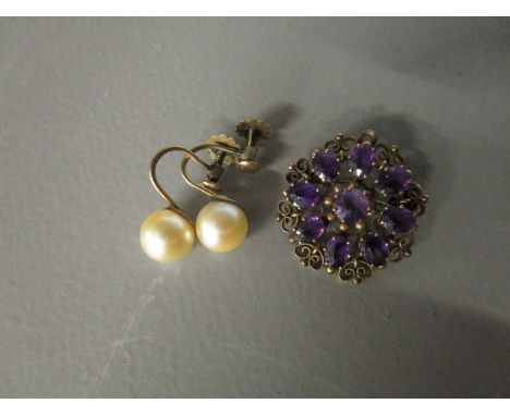A 9ct gold filigree style brooch set with amethyst coloured stone and a pair of 9ct gold pearl clip on earrings 