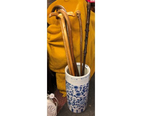 BLUE AND WHITE CYLINDRICAL POTTERY STICK STAND AND A SELECTION OF WALKING CANES