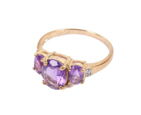 A 9ct gold and three stone amethyst ring. Having a single cut diamond to each shoulder, size Q/R, 3.1g gross