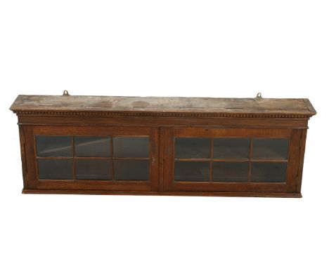 An early 20th century oak glazed wall cabinet. Having dentine pediment over two glazed doors opening to reveal a fixed shelf.