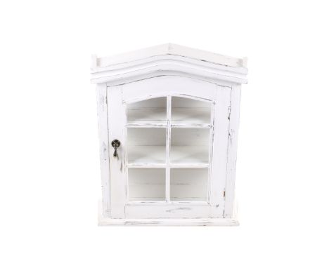 A white painted wooden wall cabinet with glazed door. Opening to reveal two shelf having an arched top. H55cm x W44cm x D16cm