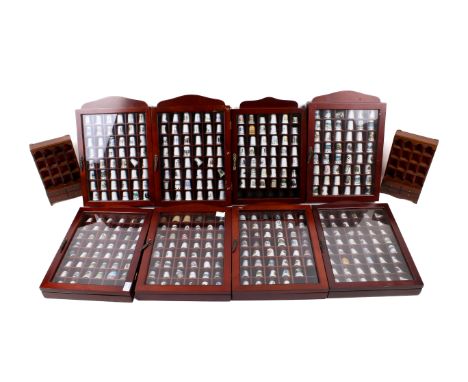 An extensive collection of thimbles. Including ceramic examples and advertising examples, within glazed display cases