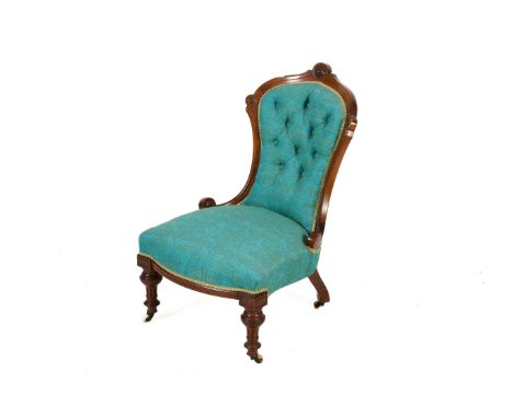 A late Victorian walnut framed nursing chair. Having turquoise blue button back upholstery, raised on reeded front supports t