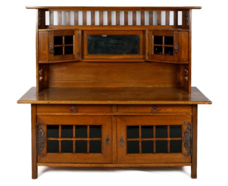 An Arts and crafts oak mirror back dresser sideboard. Raised gallery top with balustrade, central bevelled mirror flanked by 