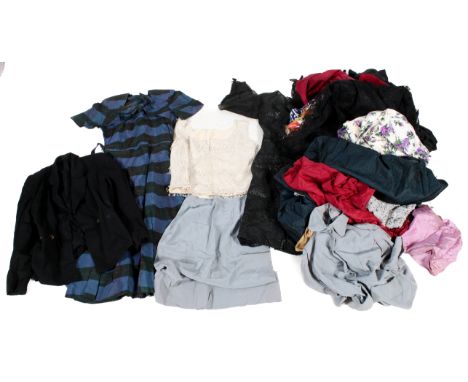 An assortment of vintage clothing and accessories. Including a beaded collar, silk blouse, black dresses, a tailored jacket, 