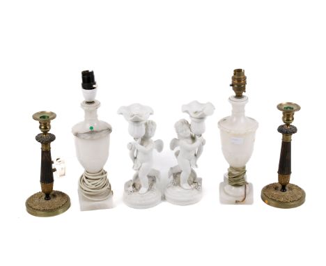 Two pairs of candlesticks and a pair of table lamps. Consisting of a brass pair, a pair of bisque porcelain cherubs and carve