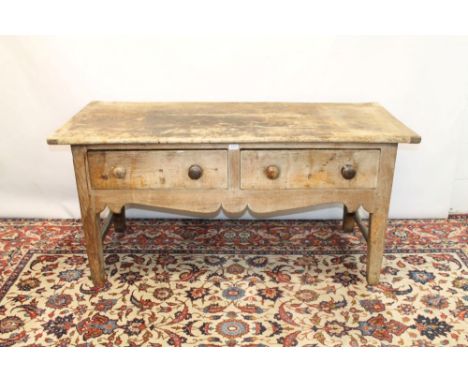 Antique pine table with plank top, the base with two short drawers above shaped apron on square supports, 151cm wide x 66cm d