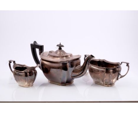 1920s three piece silver tea set, comprising teapot of fluted form with reed and ribbon border, ebonised angular handle and d