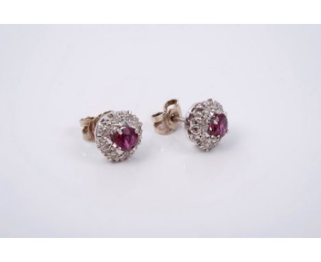 Pair ruby and diamond cluster earrings with a central mixed cut ruby surrounded by eight single cut diamonds, in illusion set