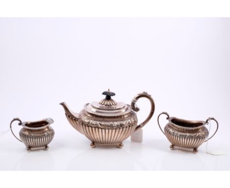 Victorian silver three piece tea set, comprising teapot of half-fluted form, with embossed scroll and floral decoration and g